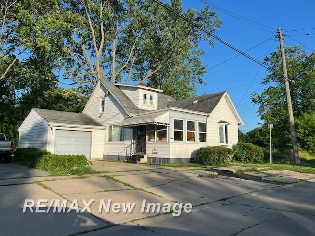 710 S 15th St, Saginaw, MI 48601 - view of front of house with a garage, concrete driveway, and a shingled roof