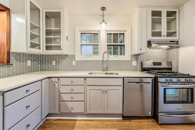 324 Highlake Ave, Ann Arbor, MI 48103 - kitchen with stainless steel appliances, under cabinet range hood, light countertops, decorative light fixtures, and backsplash