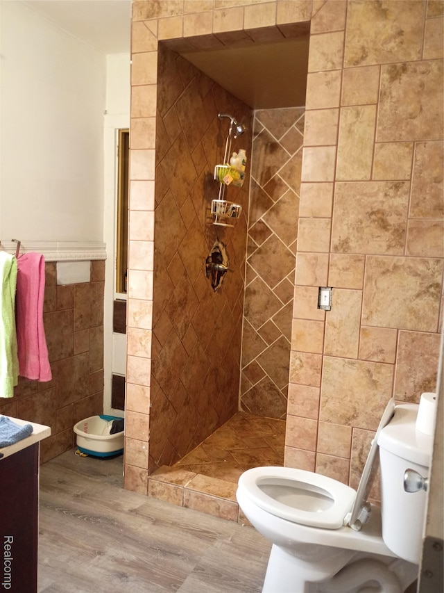 9360 Cheyenne St, Detroit, MI 48228 - bathroom featuring tile walls, wood finished floors, a stall shower, a wainscoted wall, and vanity