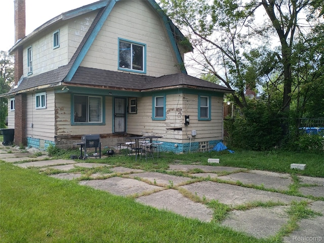 9360 Cheyenne St, Detroit, MI 48228 - view of front of property with a gambrel roof, a porch, roof with shingles, a chimney, and a front lawn