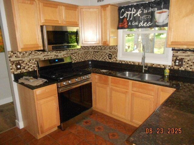 1090 Cadet Ln, Kalamazoo, MI 49009 - kitchen with appliances with stainless steel finishes, decorative backsplash, light brown cabinets, and dark stone countertops