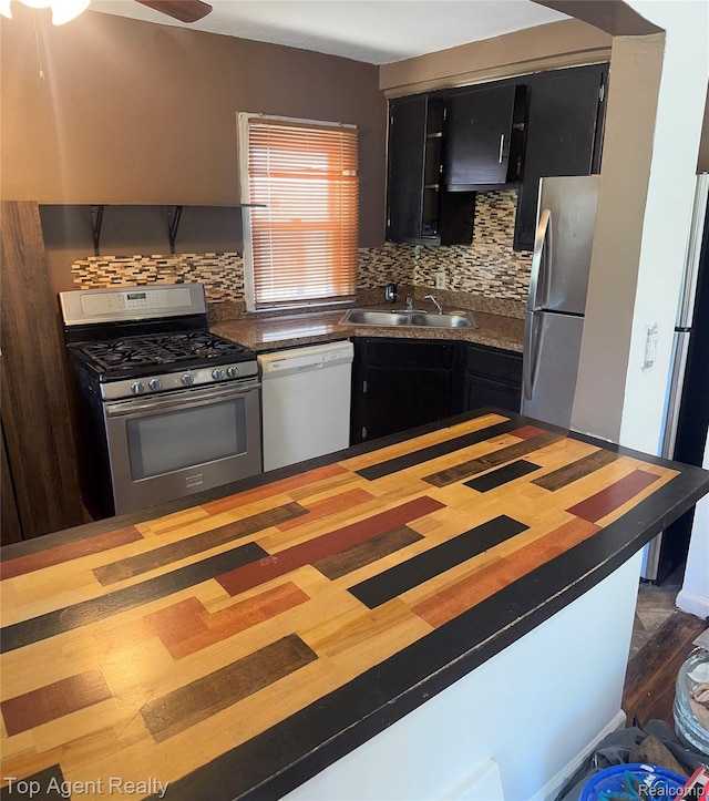 19461 Fenmore St, Redford, MI 48235 - kitchen featuring stainless steel appliances, dark cabinets, tasteful backsplash, ceiling fan, and wood finished floors