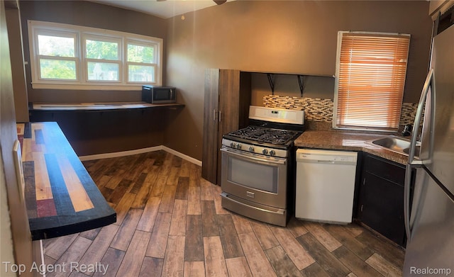 19461 Fenmore St, Redford, MI 48235 - kitchen featuring stainless steel appliances, dark countertops, dark wood-style flooring, a ceiling fan, and decorative backsplash