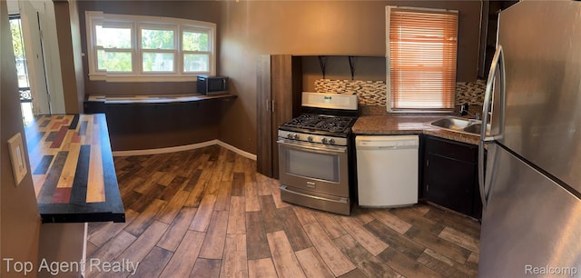19461 Fenmore St, Redford, MI 48235 - kitchen featuring stainless steel appliances, backsplash, dark wood-style floors, and dark countertops