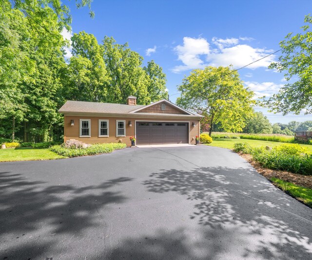 928 Curtis Rd, Quincy, MI 49082 - view of front of home featuring driveway, a garage, and a chimney