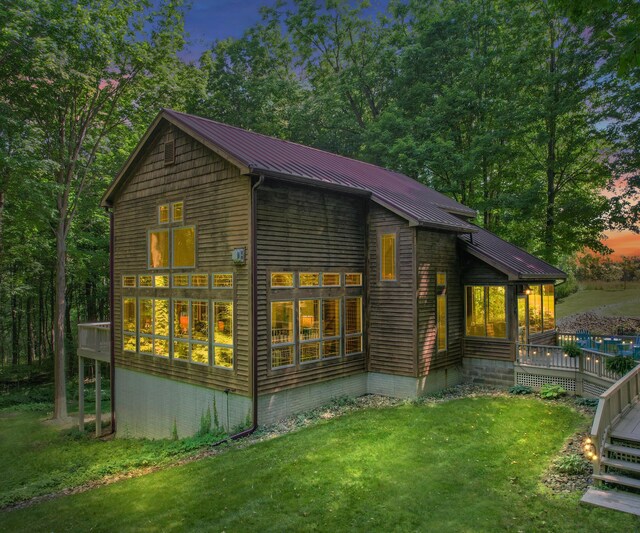 928 Curtis Rd, Quincy, MI 49082 - rear view of house featuring a yard, a wooden deck, and a metal roof