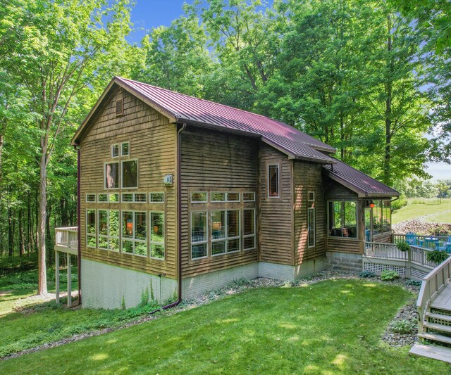 928 Curtis Rd, Quincy, MI 49082 - view of property exterior with a lawn, a metal roof, a wooden deck, and a standing seam roof