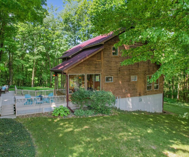 928 Curtis Rd, Quincy, MI 49082 - view of side of property featuring a metal roof, a lawn, and a deck