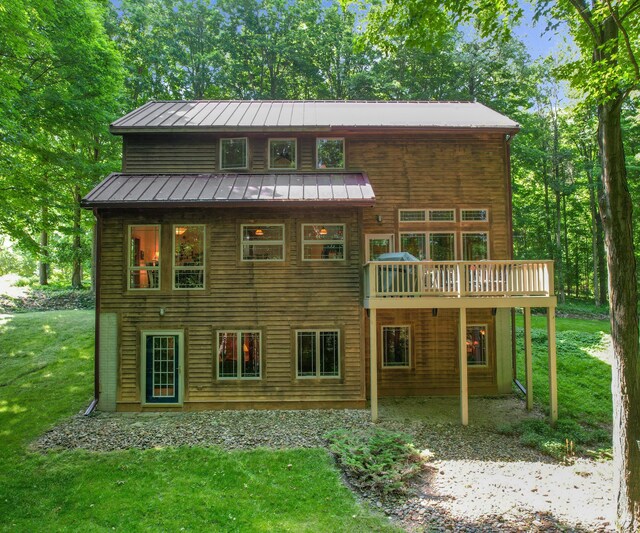 928 Curtis Rd, Quincy, MI 49082 - rear view of house featuring a yard, a standing seam roof, a deck, and a metal roof