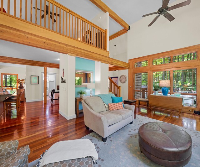 928 Curtis Rd, Quincy, MI 49082 - living area featuring a high ceiling, wood-type flooring, stairway, plenty of natural light, and beam ceiling
