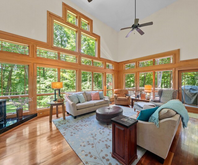 928 Curtis Rd, Quincy, MI 49082 - living area featuring a towering ceiling, ceiling fan, healthy amount of natural light, and hardwood / wood-style flooring