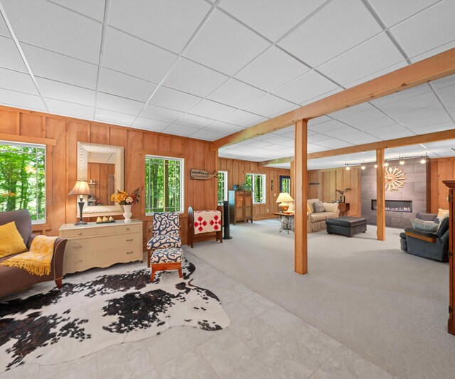 928 Curtis Rd, Quincy, MI 49082 - carpeted living area with wooden walls, a fireplace, and a paneled ceiling