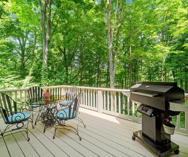 928 Curtis Rd, Quincy, MI 49082 - wooden terrace with a grill, outdoor dining area, and view of wooded area