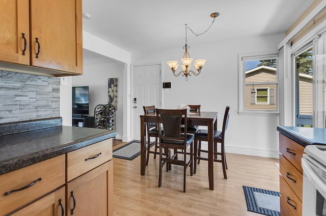 2606 S Saint Anthony St, Jackson, MI 49203 - dining area with light wood-style floors and a chandelier