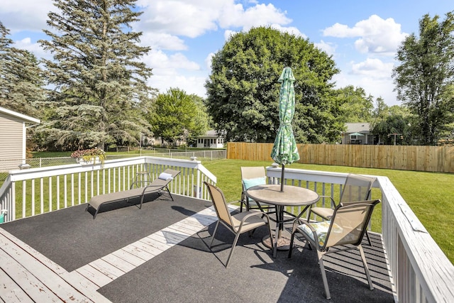 2606 S Saint Anthony St, Jackson, MI 49203 - wooden deck featuring a fenced backyard, outdoor dining space, and view of scattered trees