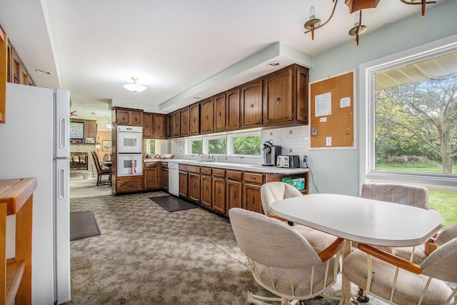 1205 Sassafras Ln, Niles, MI 49120 - kitchen with white appliances, dark carpet, light countertops, and tasteful backsplash