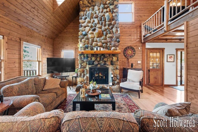 6311 142nd Ave, Holland, MI 49423 - living area with high vaulted ceiling, wood finished floors, wooden walls, wood ceiling, and a stone fireplace