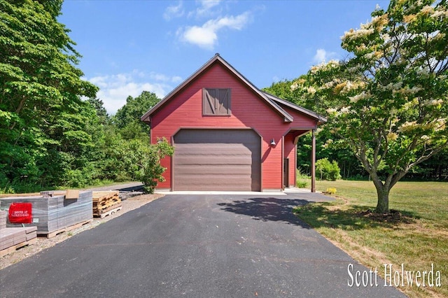 6311 142nd Ave, Holland, MI 49423 - rustic home with a garage, an outdoor structure, a front lawn, and asphalt driveway