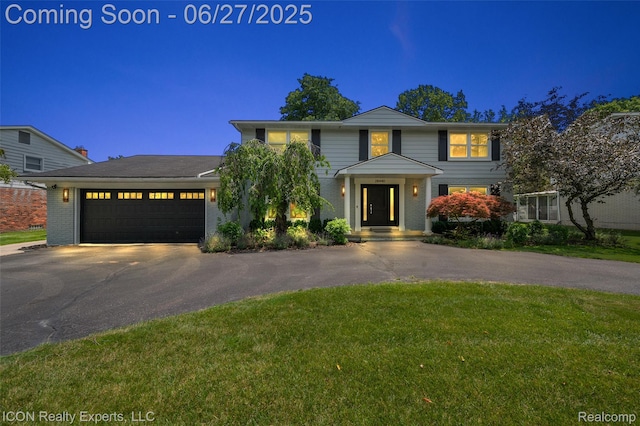 28440 Brooks Ln, Southfield, MI 48034 - traditional home featuring asphalt driveway, an attached garage, a front yard, and brick siding