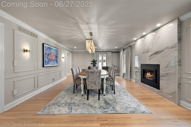 28440 Brooks Ln, Southfield, MI 48034 - dining space featuring ornamental molding, a decorative wall, a premium fireplace, light wood-style floors, and recessed lighting