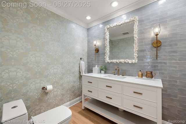 28440 Brooks Ln, Southfield, MI 48034 - bathroom featuring wood finished floors, vanity, crown molding, and wallpapered walls