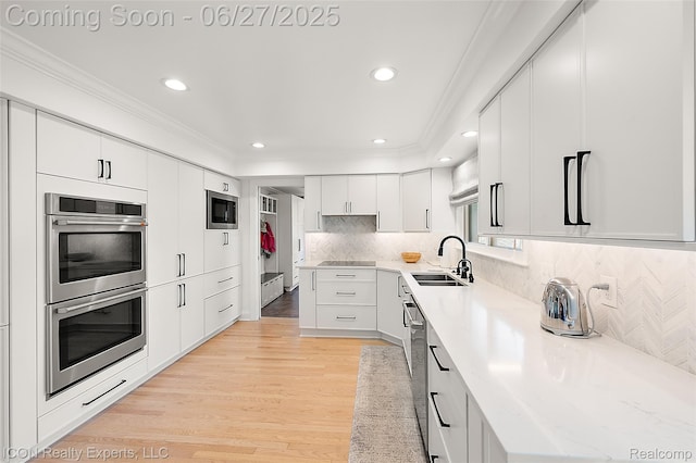28440 Brooks Ln, Southfield, MI 48034 - kitchen featuring appliances with stainless steel finishes, crown molding, recessed lighting, light wood-style floors, and white cabinetry