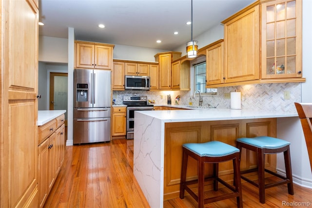 10267 Coachman Ct, Davison, MI 48423 - kitchen featuring stainless steel appliances, a peninsula, light wood-style flooring, backsplash, and recessed lighting