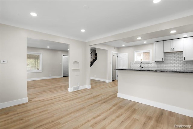 16800 Sorrento St, Detroit, MI 48235 - kitchen featuring backsplash, white cabinetry, light wood-style flooring, recessed lighting, and dark stone countertops