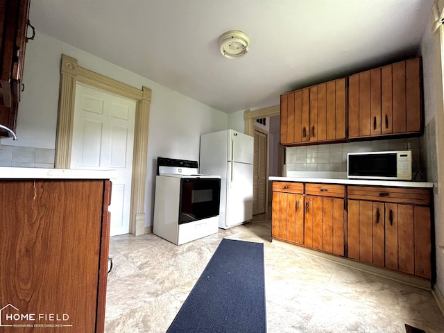 1412 Summit St, Owosso, MI 48867 - kitchen with white appliances, decorative backsplash, brown cabinets, and light countertops