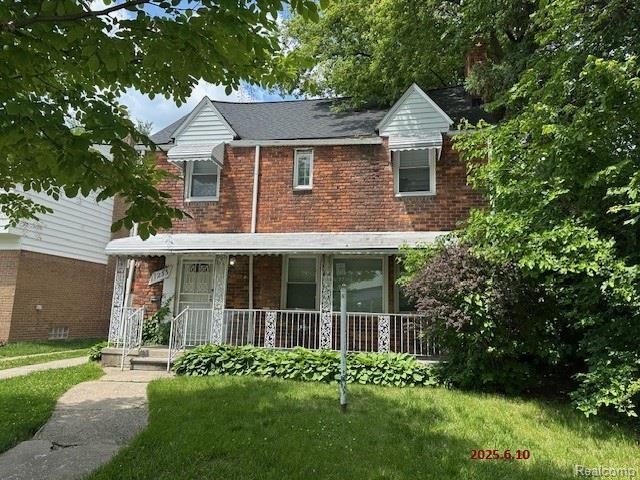 17233 Annchester Rd, Detroit, MI 48219 - view of front facade with covered porch, a front lawn, and brick siding