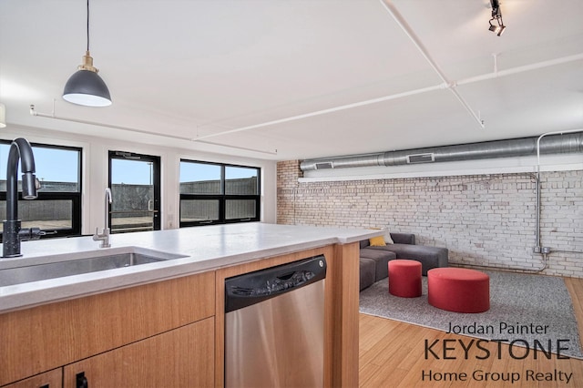 600 Broadway Ave NW Unit 409B, Grand Rapids, MI 49504 - kitchen with dishwasher, brick wall, open floor plan, light wood-style flooring, and light countertops