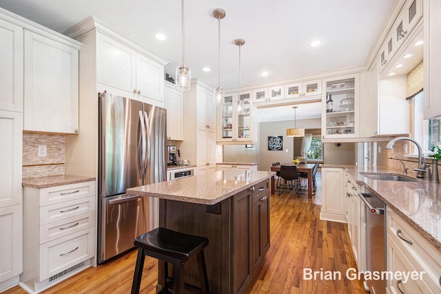 539 Overbrook Ln SE, Grand Rapids, MI 49507 - kitchen featuring appliances with stainless steel finishes, a kitchen island, light wood-type flooring, white cabinets, and recessed lighting