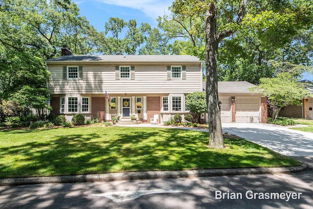 539 Overbrook Ln SE, Grand Rapids, MI 49507 - colonial inspired home featuring brick siding, a chimney, an attached garage, concrete driveway, and a front lawn