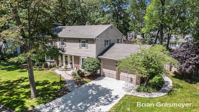 539 Overbrook Ln SE, Grand Rapids, MI 49507 - view of front of house with brick siding, a garage, a front yard, driveway, and a shingled roof