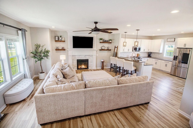 11539 Warrior Trl, Grass Lake, MI 49240 - living area featuring light wood finished floors, ceiling fan, a glass covered fireplace, and recessed lighting