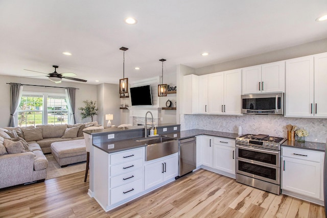 11539 Warrior Trl, Grass Lake, MI 49240 - kitchen with appliances with stainless steel finishes, open floor plan, dark countertops, a peninsula, and recessed lighting
