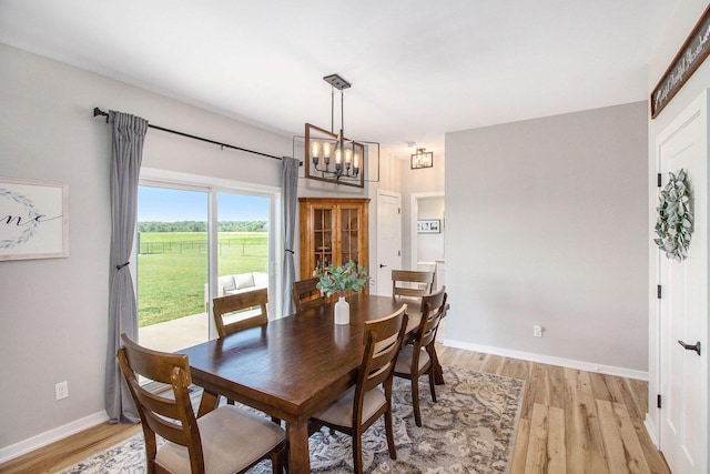 11539 Warrior Trl, Grass Lake, MI 49240 - dining room featuring a chandelier and light wood-type flooring