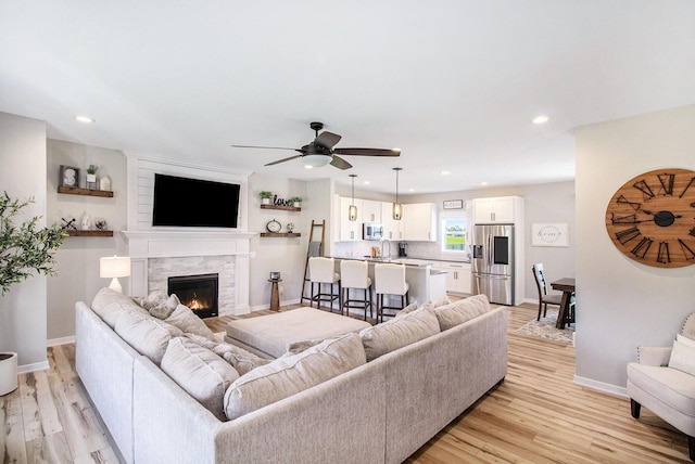 11539 Warrior Trl, Grass Lake, MI 49240 - living area featuring light wood finished floors, recessed lighting, ceiling fan, and a fireplace