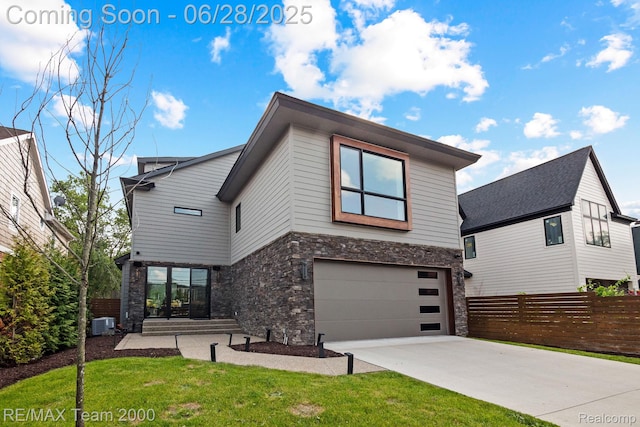 927 Ann St, Birmingham, MI 48009 - view of front of home featuring stone siding, driveway, and a garage