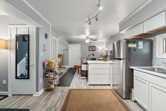 1645 Chlebus St, Jackson, MI 49203 - kitchen featuring freestanding refrigerator, light wood-style flooring, white cabinets, ceiling fan, and light countertops