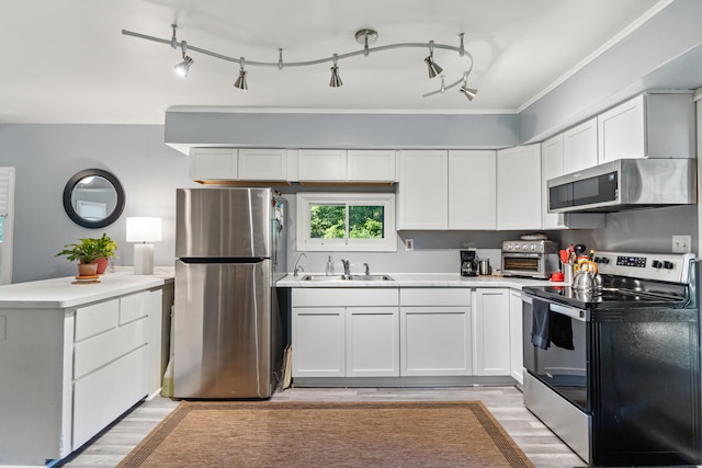 1645 Chlebus St, Jackson, MI 49203 - kitchen with appliances with stainless steel finishes, a peninsula, light wood-style flooring, white cabinets, and crown molding
