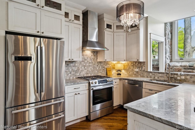 229 E Commerce St Unit 1, Milford, MI 48381 - kitchen with stainless steel appliances, wall chimney range hood, light stone countertops, dark wood-style floors, and tasteful backsplash