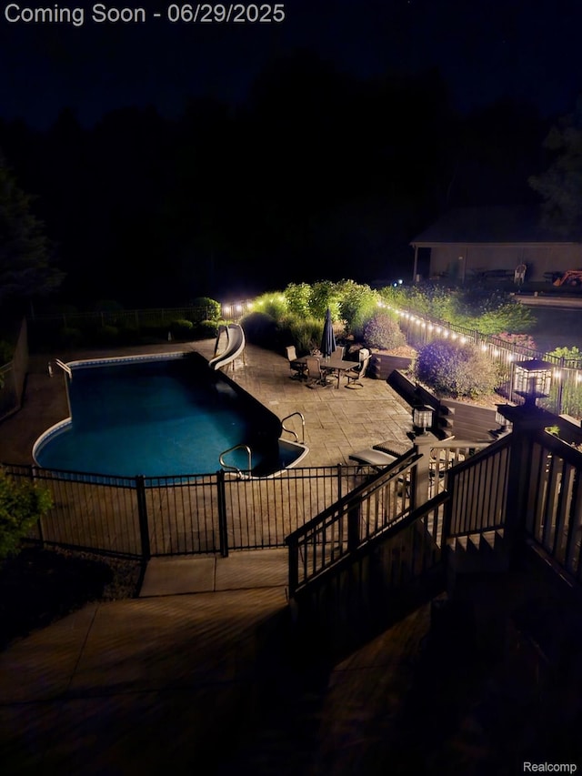 4301 Rolling Acres Dr, Hartland, MI 48353 - pool at night with a water slide and a patio