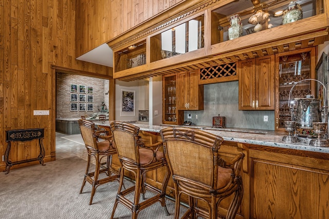 861 S 800 W, Indiana, IN 46341 - kitchen featuring brown cabinets, wooden walls, a high ceiling, light stone counters, and backsplash