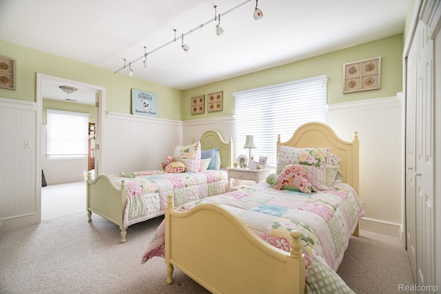 3831 Woodland Dr, Highland, MI 48356 - carpeted bedroom with wainscoting and track lighting