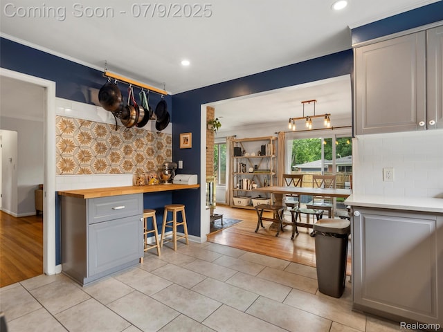 32000 Coronet Dr, Farmington, MI 48334 - kitchen with butcher block countertops, light tile patterned flooring, backsplash, crown molding, and recessed lighting