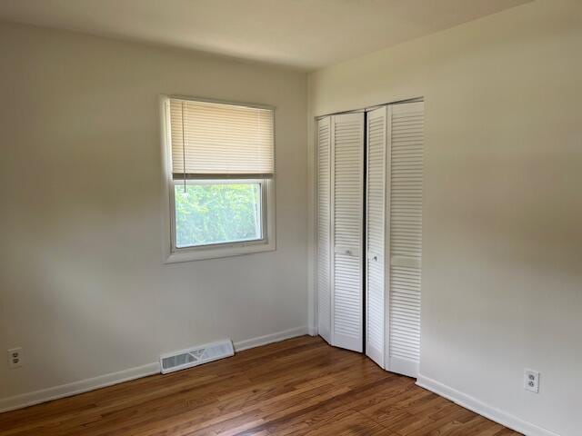 846 Hancock St SE, Grand Rapids, MI 49507 - unfurnished bedroom with a closet and wood finished floors