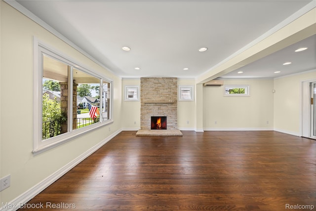 643 Spencer St, Ferndale, MI 48220 - unfurnished living room with dark wood-style floors, a wall mounted air conditioner, a stone fireplace, ornamental molding, and recessed lighting