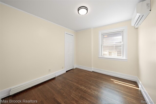 643 Spencer St, Ferndale, MI 48220 - empty room featuring a wall mounted air conditioner, dark wood finished floors, and a baseboard heating unit