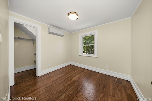 643 Spencer St, Ferndale, MI 48220 - unfurnished bedroom with a wall mounted AC, wood finished floors, crown molding, a closet, and a walk in closet